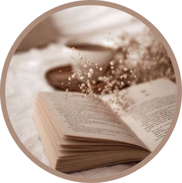 an open book sitting on top of a table next to a cup and saucer