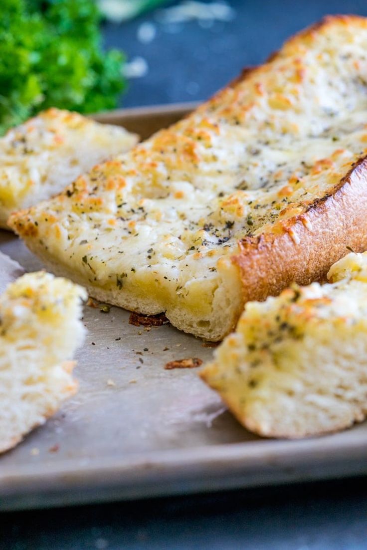 garlic bread on a baking sheet with parsley