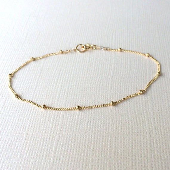 **Please note: My current production time is 5-10 business days.**  Satellite BraceletTiny gold beads are scattered on a very dainty 14k gold fill curb chain. Securely wire wrapped at the ends with a small 14k gold filled clasp.  Modern, simple and great for layering with other bracelets.Details:~Gold beads measure 1mm.~Dainty chain and findings are 14k gold fill.~Bracelet length is customizable from 6-8 inches.Every Marigold Mary purchase will arrive beautifully packaged in a small gift box.Vie Dainty Yellow Gold Beaded Bracelets In 14k Gold Filled, Gold Minimalist Chain Bracelet With Gold Beads, Minimalist Gold Chain Bracelet With Gold Beads, Gold Chain Bracelet With Gold Beads For Everyday, Everyday Gold Chain Bracelet With Beads, Dainty 14k Gold-filled Beaded Bracelets, Everyday Chain Bracelet With Round Beads, Gold Minimalist Chain Bracelet With Round Beads, Gold Beaded Chain Bracelet In 14k Gold Filled