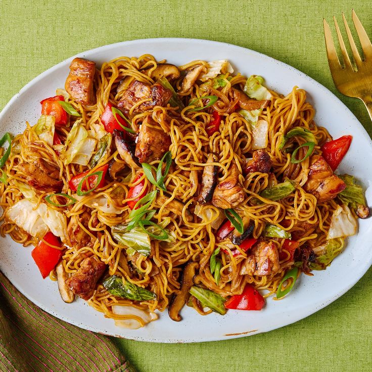 a white plate topped with noodles and meat