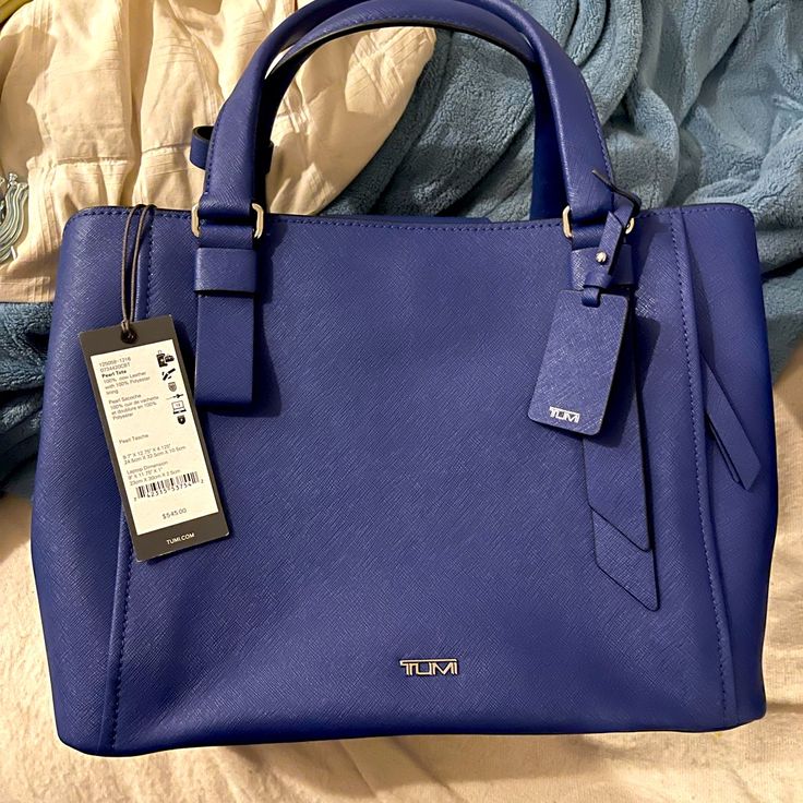 This Gorgeous Tumi Varek Handbag In Royal Blue Is Brand New With Tags. It’s Classy, Eye Catching, And Boasts Of That Durable, High Quality Craftsmanship We’ve Come To Love From Tumi. Blue Top Handle Bag For Office, Blue Top Handle Shoulder Bag For Office, Blue Shopping Bag With Detachable Handle, Modern Blue Top Handle Bag, Blue Formal Bag With Adjustable Strap, Formal Blue Bag With Adjustable Strap, Blue Satchel With Adjustable Strap For Formal Use, Blue Office Satchel With Detachable Handle, Blue Rectangular Satchel With Handles