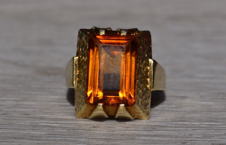 The Whitsett: Ladies Mid Century Citrine Cocktail Ring in 14K Yellow Gold. Crafted in 14 karat white gold is this mid century style statement ring. Set in the center of this ring is a 13mm x 9mm emerald cut citrine. The ring is stamped Germany and is currently a finger size 7.5 yet can be adjusted in size for an additional charge upon request. Love this piece, but don't have the money to spend right now?  We offer FREE layaway on every item in our shop.  With just 20% down, take one full year (i Retro Polished Rings For Formal Events, Retro Formal Rings With Polished Finish, Retro Rings With Polished Finish For Formal Occasions, Modern Formal Hallmarked Topaz Ring, Retro 14k Gold Formal Rings, Retro 14k Gold Rings For Formal Occasions, Modern Citrine Rings For Formal Occasions, Formal Retro 14k Gold Rings, Retro Orange Jewelry For Formal Events