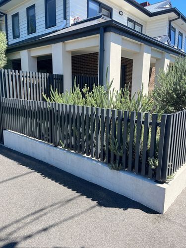 a white house with a black fence in front of it