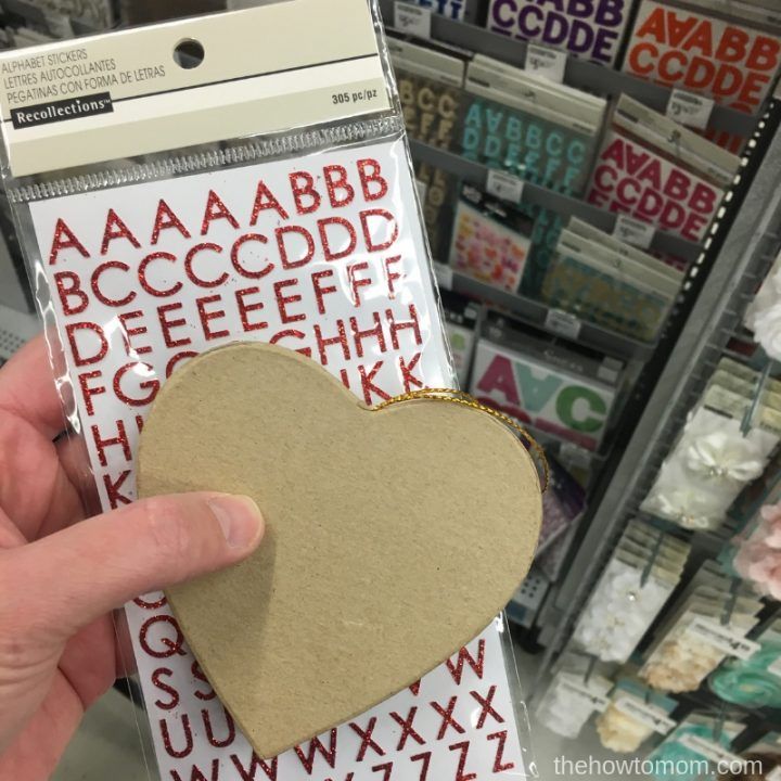 someone holding up a heart shaped piece of cardboard