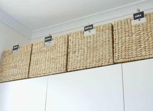 three baskets are hanging on the wall above some cupboards with labels that read'sale '