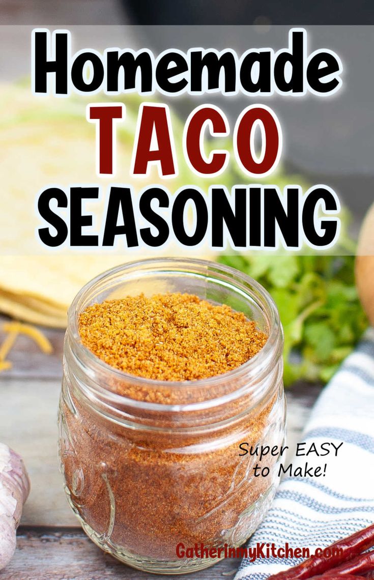 homemade taco seasoning in a glass jar on top of a wooden table next to vegetables