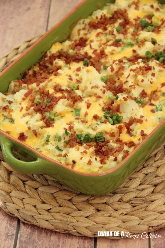 a green casserole dish filled with bacon and cheese on a wicker basket