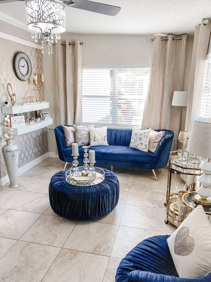 a living room filled with furniture and a chandelier hanging from the ceiling in front of a window