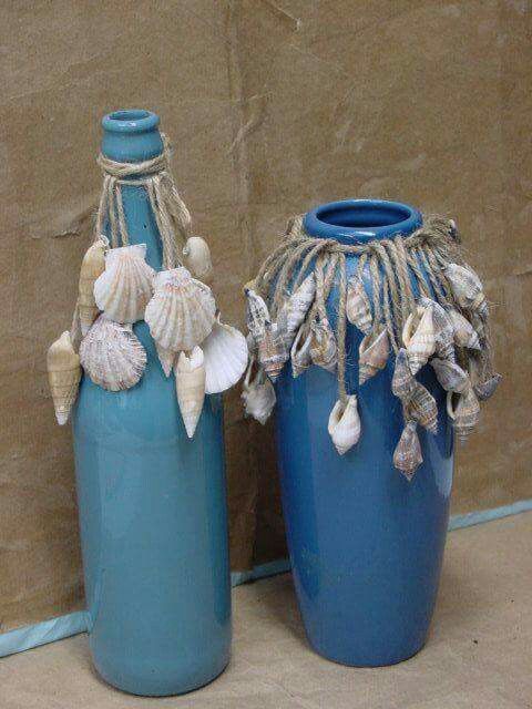 two blue vases sitting next to each other with shells on the top and bottom