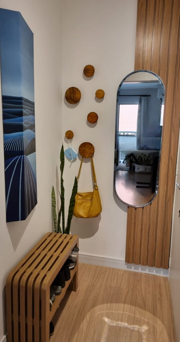 a wooden bench sitting under a mirror next to a wall filled with pictures and plants