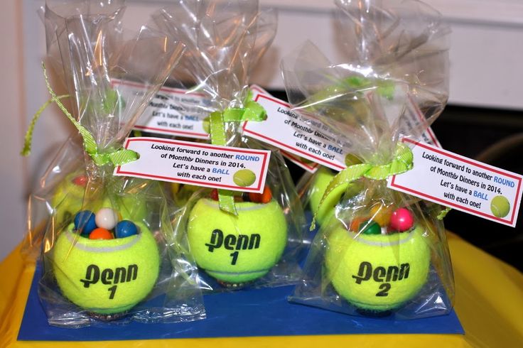 three tennis balls wrapped in plastic bags with name tags on them sitting on a table