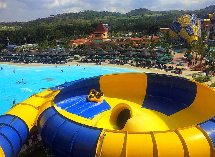 an inflatable water slide at the beach with people swimming and riding on it