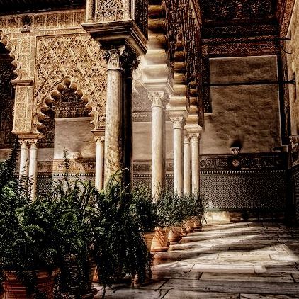 an ornate building with columns and potted plants