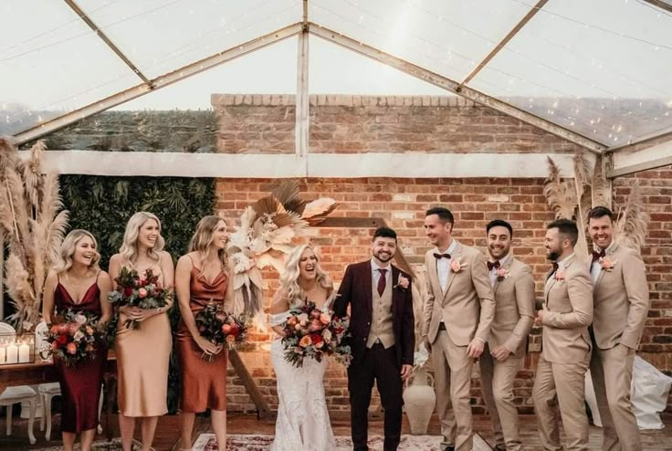 a group of people standing next to each other in front of a brick wall and ceiling