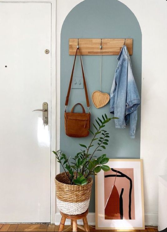 a potted plant sitting on top of a wooden stand next to a white door