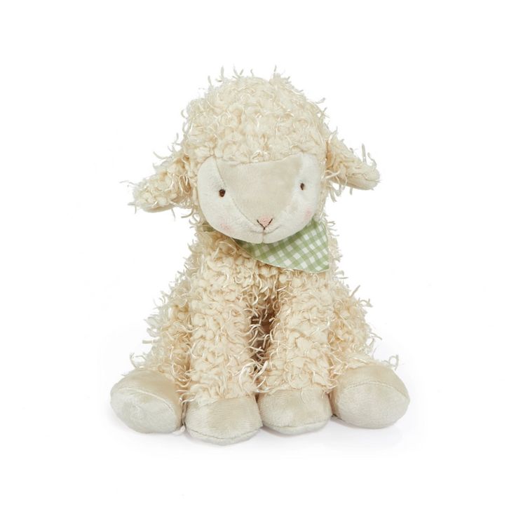 a white stuffed sheep with a green bow tie on it's neck, sitting in front of a white background