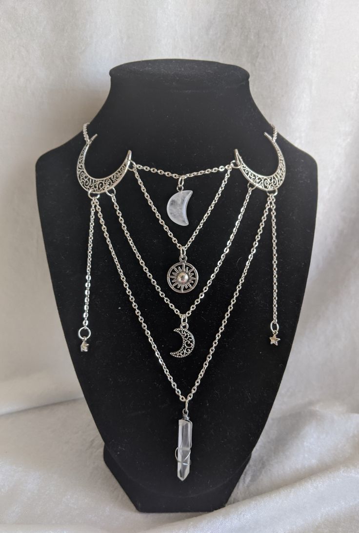 This gorgeous necklace looks like a layered piece, but is actually all in one! No hassle of putting on/taking off multiple necklaces, this piece gives off a witchy, magical look. The necklace features moons, stars, a sun, and a crystal moon and stick arranged in a uniquely magical way! Perfect for special occasions or to add a little magic to your everyday Choose between silver and bronze Choose between an amethyst moon and stick or a clear quartz moon and stick The shortest chain measures at 16 Mystical Silver Necklace For Party, Celestial Silver Necklace For Party, Silver Celestial Necklace For Party, Magical Moon Phase Necklace, Silver Celestial Party Necklace, Silver Moon Phase Necklaces For Party, Silver Moon Phase Necklace For Party, Bohemian Moon Charm Jewelry For Party, Silver Witchy Choker Jewelry