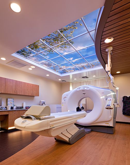 a modern dental room with skylight and large white machine in the center, on hard wood flooring