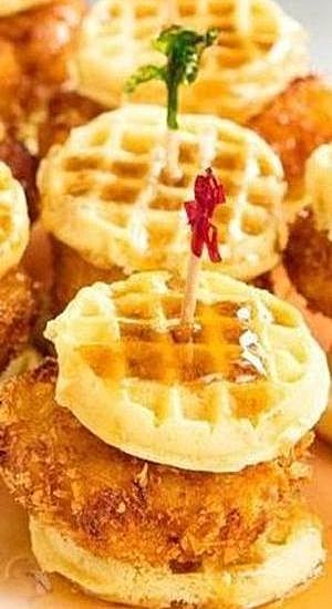 fried chicken and waffles are arranged on top of each other, with a tiny toothpick sticking out of the middle