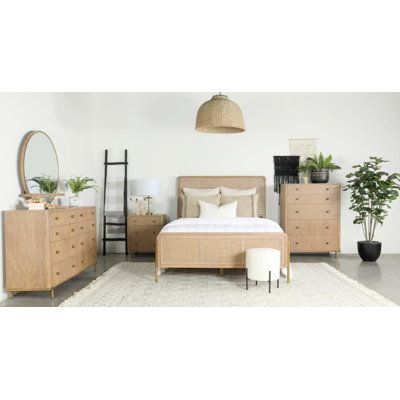 a bed room with a neatly made bed and two planters on the dressers