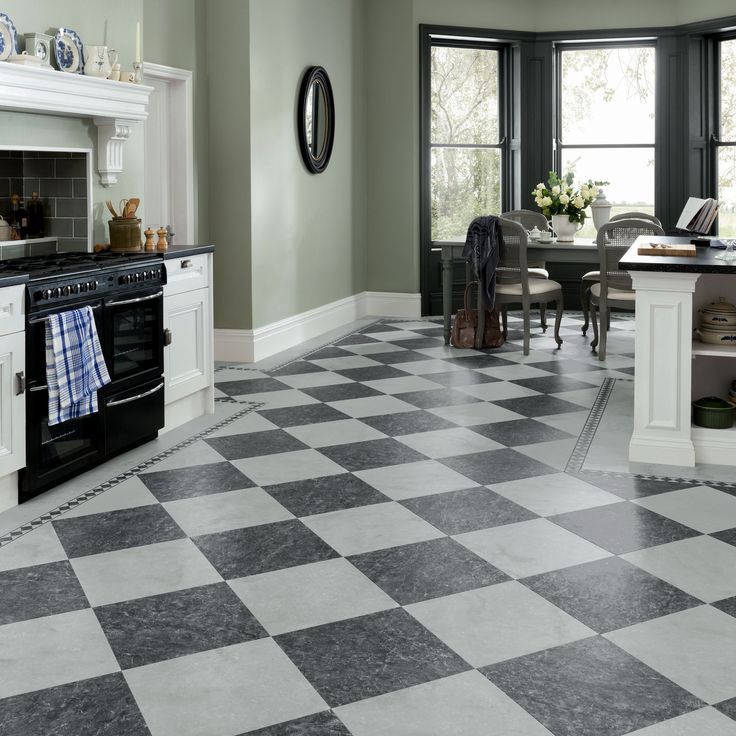 a kitchen with black and white checkered flooring next to a stove top oven