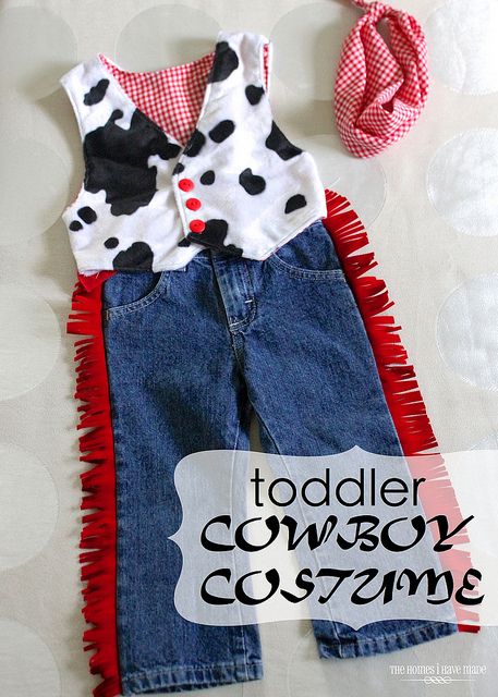 a toddler cowboy costume with red and white polka dots on the collar, blue jean overalls, and a hair bow