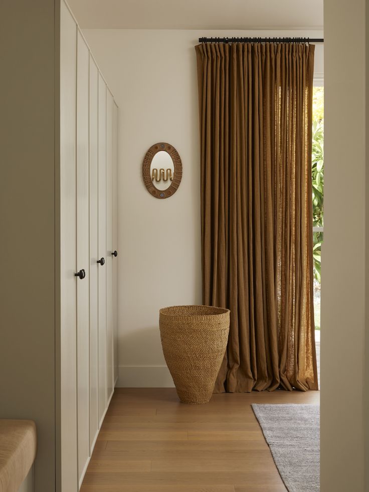 a large vase sitting in the middle of a room next to a window with drapes