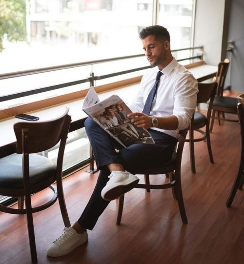 a man sitting in a chair reading a newspaper