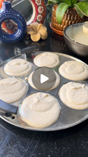 a pan filled with food sitting on top of a counter next to bowls and plates