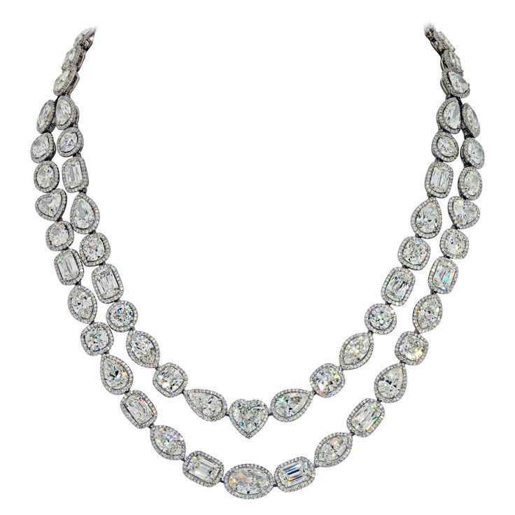 A beautiful example of how fancy shapes can really create a statement piece of jewelry is this diamond necklace by William Goldberg. Designed as a two-row swag of Ashoka [brand name for a round-cornered rectangular modified-brilliant cut], cushion, marquise, circular, pear, rectangular, oval, and heart-shaped diamonds, each within a circular-cut diamond surround... and mounted in platinum. GIA quality analysis: 48 of the diamonds were graded by GIA. Exceptional sparkle and brilliance! Total carat weight of all diamonds: 63 cttw. Center diamonds range from 1 to 2 carats each. Length: drops to 17 inches. Necklace Design Ideas, Diamond Infinity Necklace, Diamond Drop Necklace, Marquise Shape Diamond, Retro Bracelet, Expensive Jewelry Luxury, David Webb, Diamond Necklace Set, Von Dutch