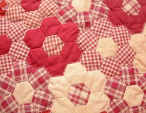 a red and white checkered table cloth with hexagons on it's edges