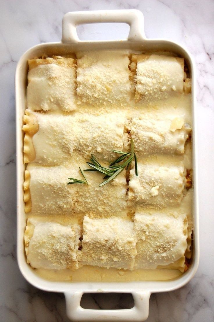 a casserole dish with cheese and herbs in it