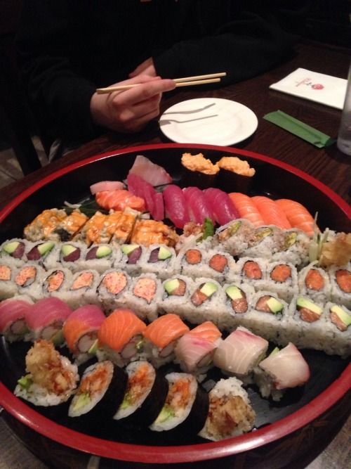 sushi platter with several different types of sushi and chopsticks on it