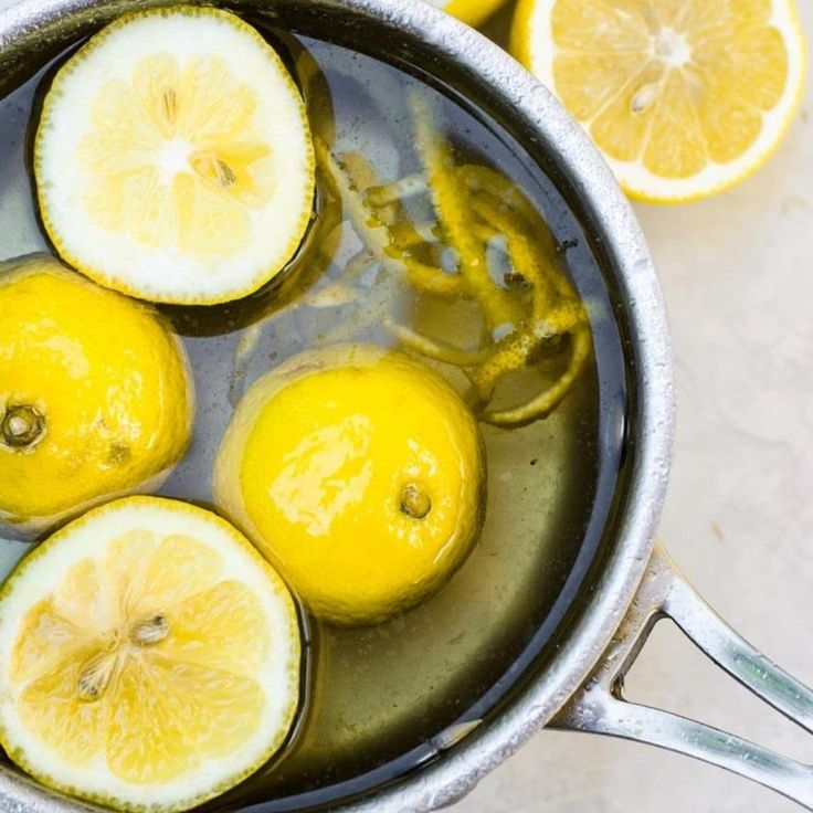 lemons and other fruits are in a pot with boiling water on the counter top