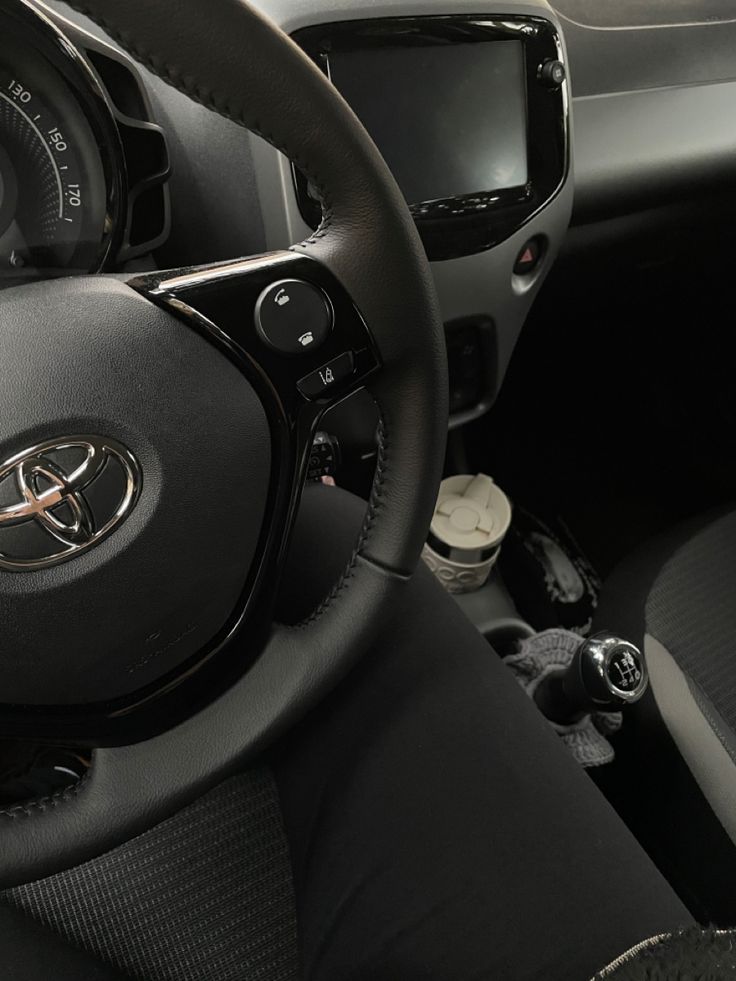 the interior of a car with steering wheel controls and dashboard buttons, including an electronic display