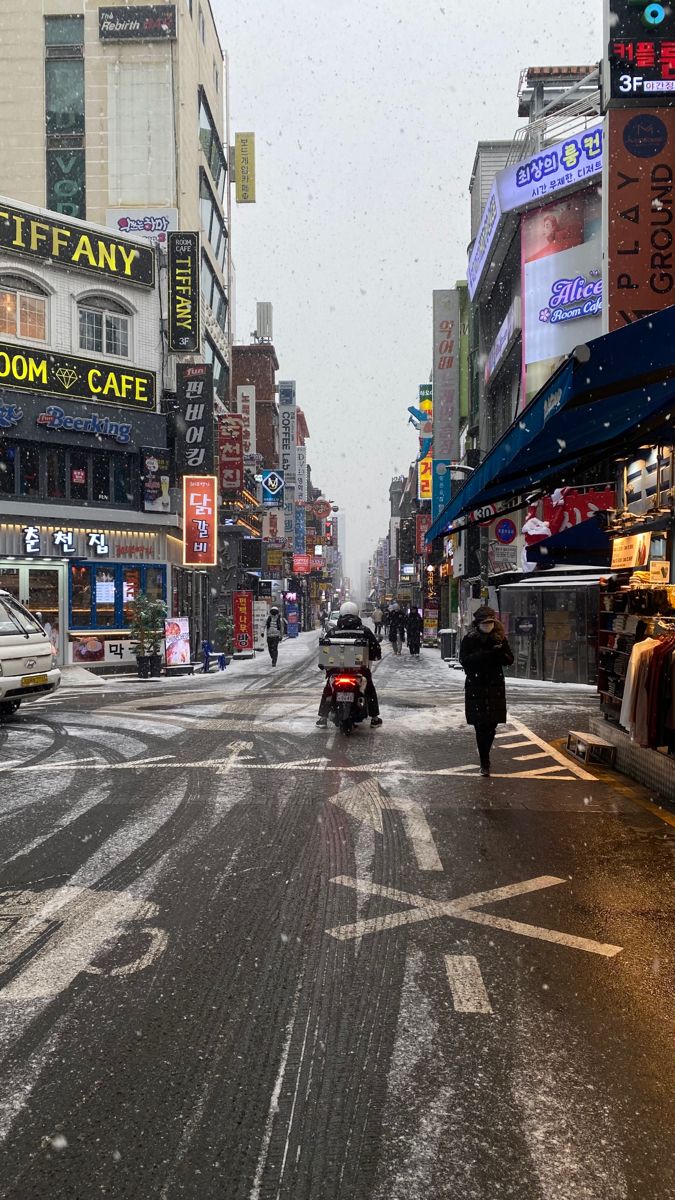 people are walking down the street on a snowy day