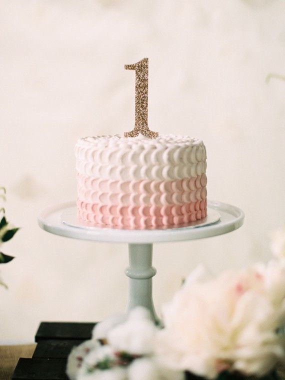 a pink and white cake sitting on top of a table