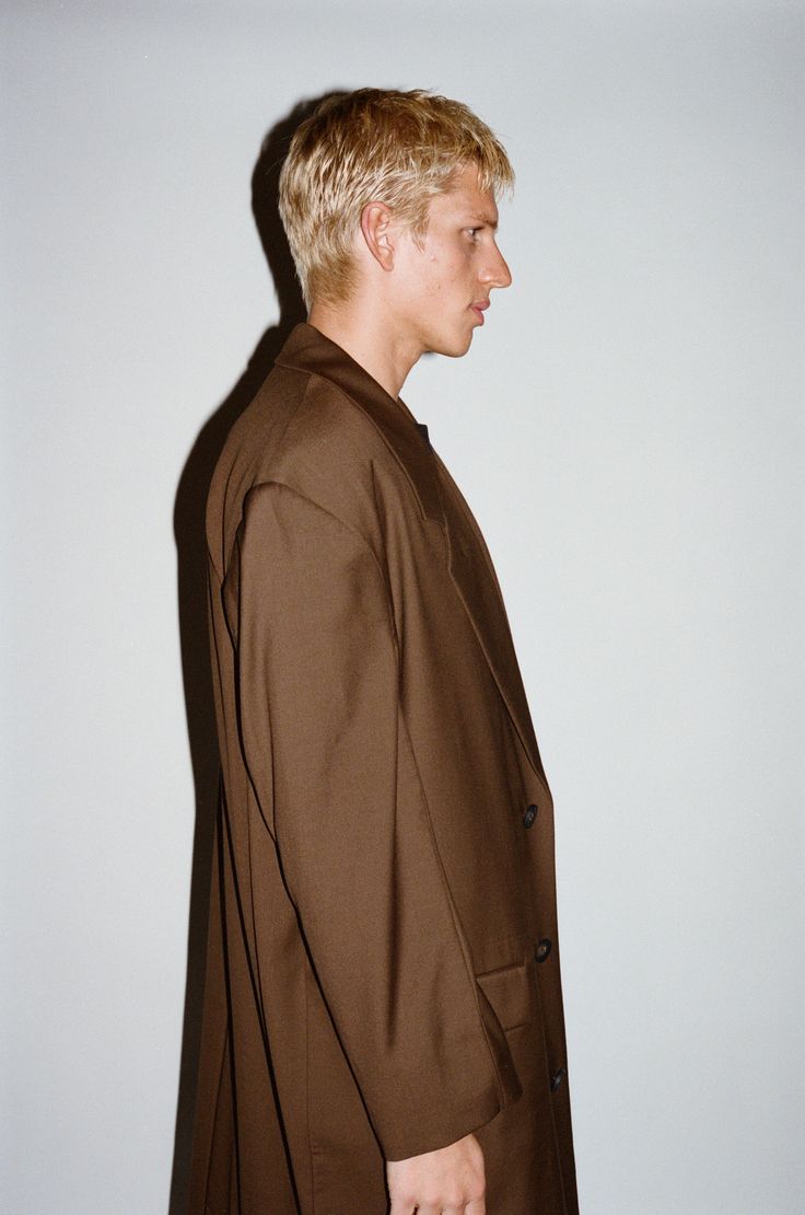 A pared-down sartorial classic with an irreverent twist. This statement structural coat is tailored to perfection with sharp, broad shoulders and clean lines. Constructed in a supremely soft & fluid 100% lightweight wool that drapes below the knee, this layer offers a dose of sophistication to transitional dressing. Modern Structured Outerwear, Oversized Notch Lapel Wool Coat For Formal Occasions, Modern Outerwear With Structured Boning, Oversized Wool Coat With Notch Lapel For Formal Occasions, Modern Structured Outerwear With Boning, Classic Spring Outerwear With Structured Boning, Spring Classic Outerwear With Structured Boning, Spring Office Outerwear With Structured Boning, Modern Blazer With Structured Boning And Long Sleeves