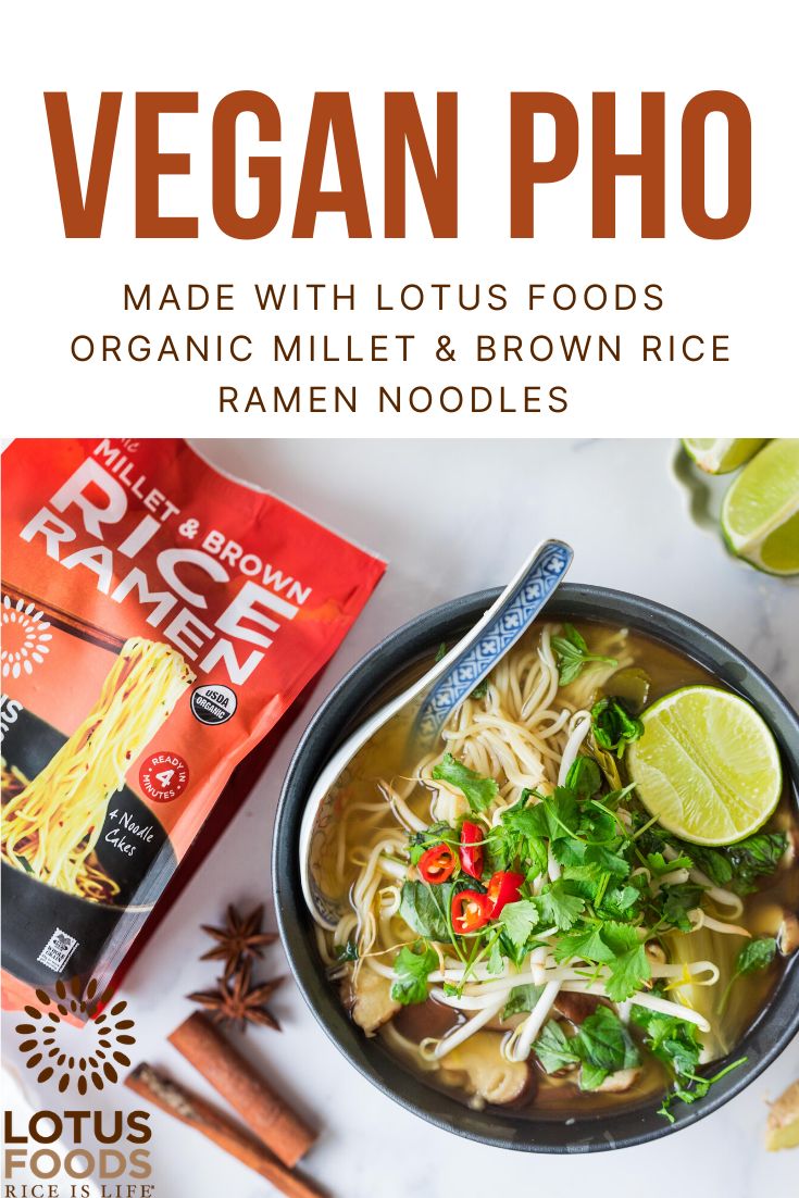 a bowl of soup with noodles, carrots and greens on the side next to a bag of vegan pho made with lotus foods organic millet & brown rice ramen noodles