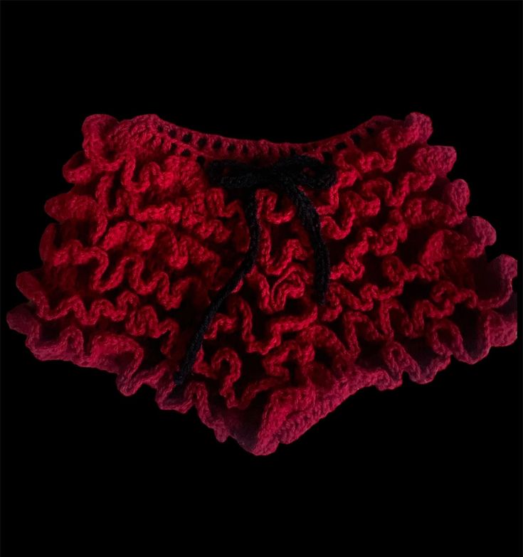 red crocheted shorts with black drawstrings on the bottom and side