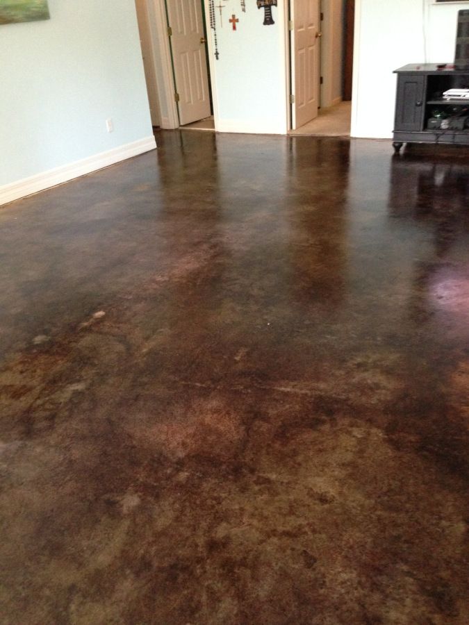 a living room with a brown floor and white walls