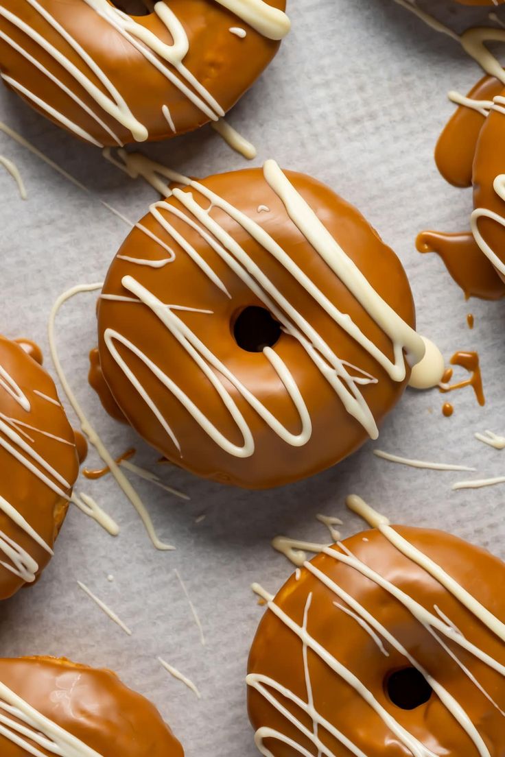 chocolate covered donuts with white icing and drizzled on the top