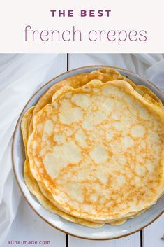 three pancakes on a plate with white cloth