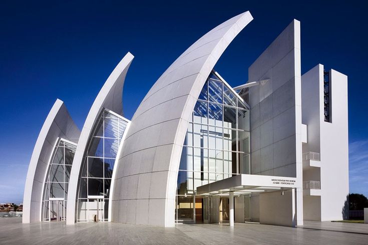 a large white building with many windows on it's sides and the sky in the background