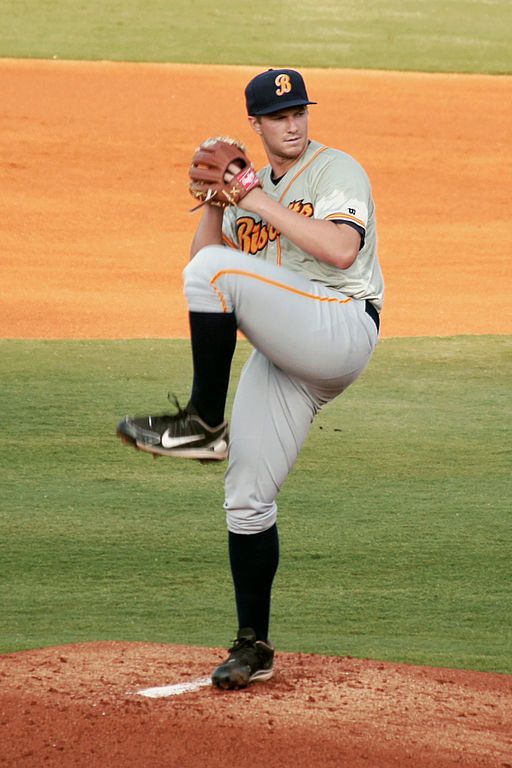 a baseball player pitching a ball on top of a field in the middle of a pitch