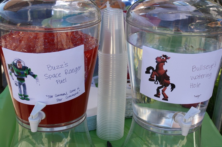 two plastic containers filled with red liquid on top of a green table next to each other