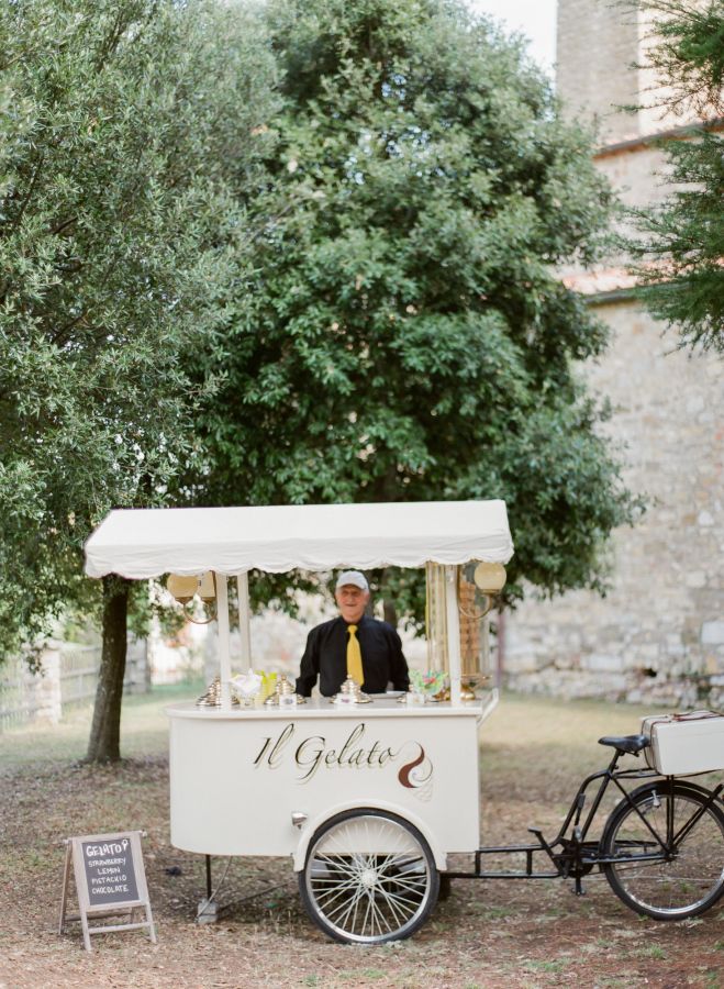 a man standing behind a food cart with a sign on the front that says it golden