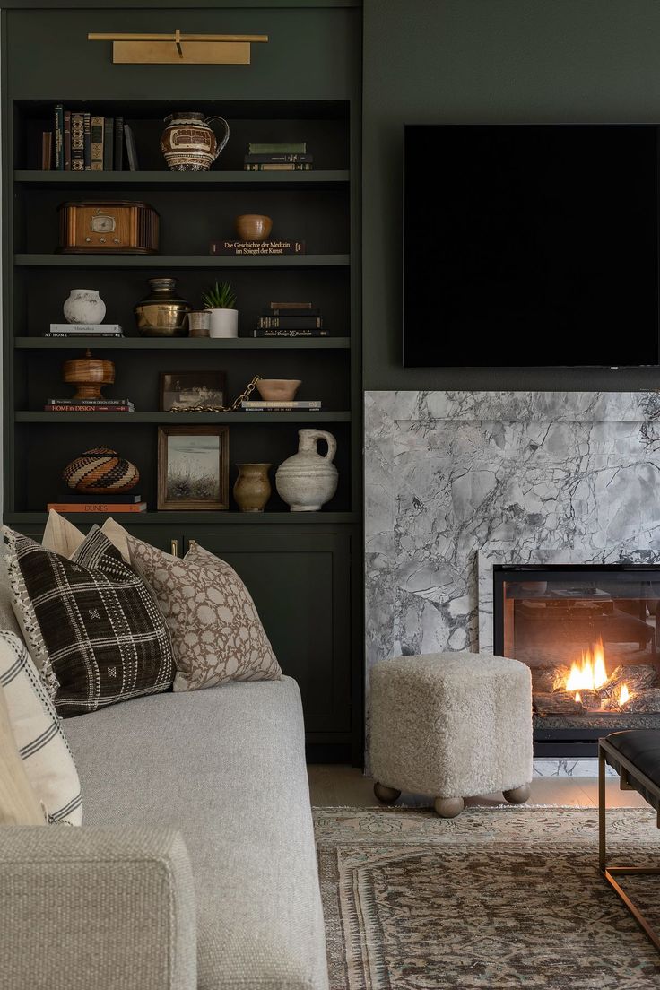 a living room filled with furniture and a fire place in front of a flat screen tv