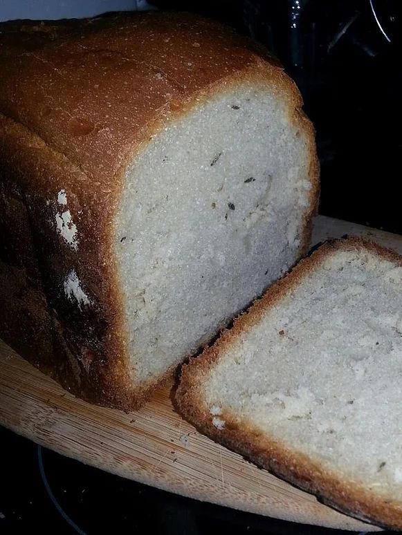 a loaf of bread sitting on top of a wooden cutting board