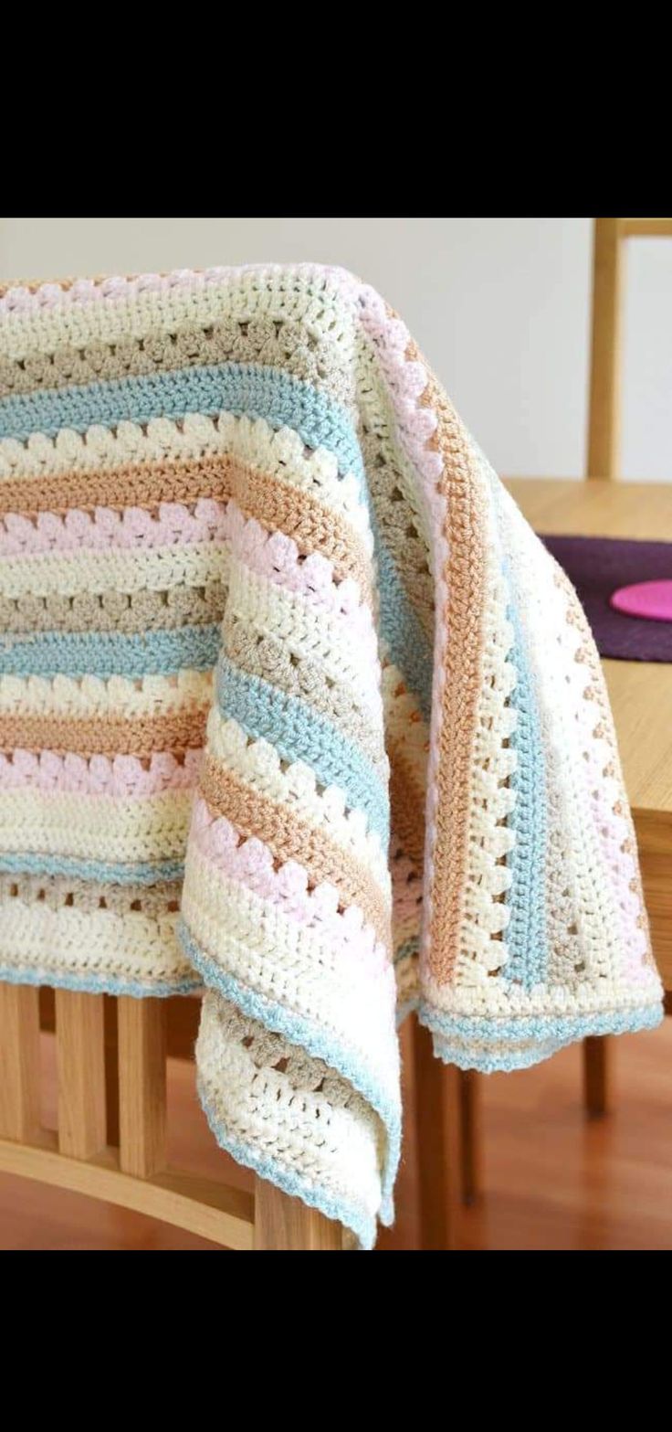 a crocheted blanket sitting on top of a wooden chair